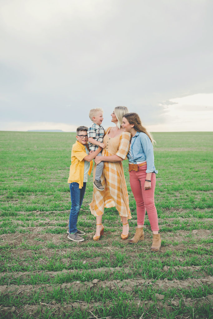 a family of four in a field showing great style with beautiful colors